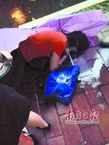 雨中撑伞唯美图片 女子雨中伏地数十分钟 路人为其撑伞却不敢施救